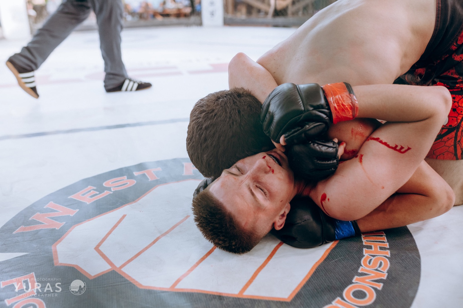 Two fighters work for a submission on the canvas.